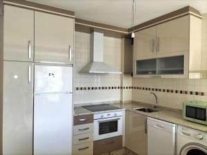 a kitchen with white appliances and a white refrigerator at Bonito y acogedor apartamento en Castropol in Castropol