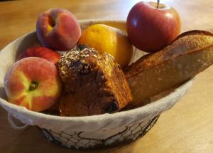 un bol de fruta con manzanas y pan en una mesa en D'En Haut tentes suspendues, en Saint-Pardoux