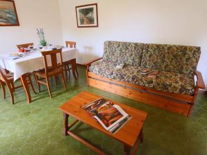 uma sala de estar com um sofá e uma mesa em Apartment by the sea in special surroundings em Santa Liberata