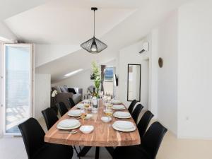 une salle à manger avec une grande table en bois et des chaises noires dans l'établissement Modern villa in Nin by the sea, à Nin