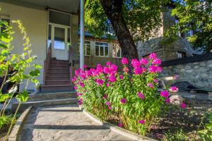 una casa con fiori rosa davanti di Seti Tower Guest House a Mestia