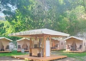 a group of tents in a field with trees at Divoto Glamping in Balchik