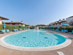 コマッキオにあるCosy Apartment in Lido delle Nazioni with Poolの大きなスイミングプール(青い椅子、噴水付)