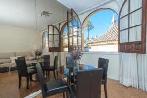 a living room with a glass table and chairs at Apartamento con vistas a la Giralda. in Seville