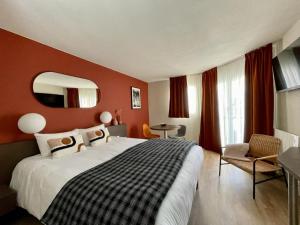 Pokój hotelowy z dużym łóżkiem i lustrem w obiekcie Résidence Les Baladines w mieście Thonon-les-Bains