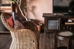 - Silla de mimbre con almohada en la sala de estar en 浜名湖オーベルジュ　キャトルセゾン, en Ōsaki