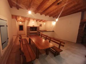 a dining room with a wooden table and benches at Villa Copun with heated pool in Rab