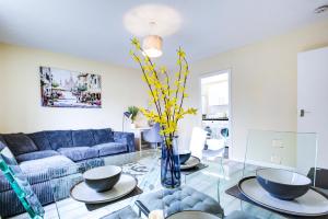 a living room with a blue couch and a glass table at Inviting Urban Apartment in Croydon in Croydon