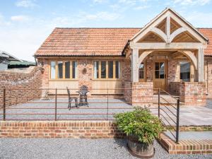 a brick house with a gate and a patio at The Red Rooster - Uk44440 in Arlingham