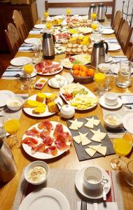 A Casa da Eira في Cerreda: طاولة طويلة عليها أطباق من الطعام