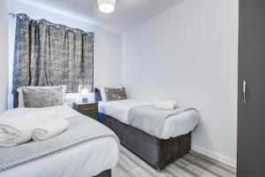a bedroom with two beds and a window at Inviting Urban Apartment in Croydon in Croydon