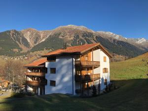a large building with a mountain in the background at Plattis 4 in Klosters