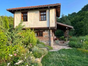 a stone house with a garden in front of it at Traditional Cottage - Vila Samovila in Delčevo