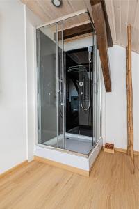 um chuveiro de vidro no canto de um quarto em Kamienna Top studio - BillBerry Apartments em Gdynia