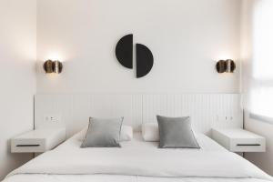 1 dormitorio blanco con 1 cama blanca y 2 mesitas de noche en Port Forum Apartments by Olala Homes, en Barcelona