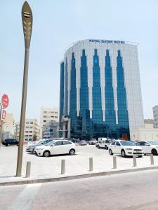 un estacionamiento con autos estacionados frente a un edificio en Royal Qatar Hotel, en Doha