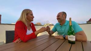 un hombre y una mujer sentados en una mesa con una botella de vino en AVA Flats, en Alicante