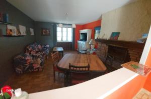 ein Wohnzimmer mit Tisch und Kamin in der Unterkunft Vacances à la campagne in Noirétable