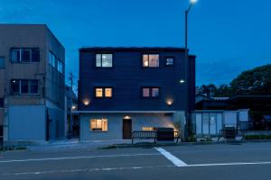een gebouw met een bank voor een gebouw bij NODE SAIGAWA in Kanazawa