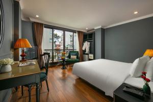 una camera d'albergo con letto, scrivania di La Selva Premium Hotel a Hanoi
