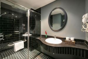 een badkamer met een wastafel en een spiegel bij La Selva Premium Hotel in Hanoi