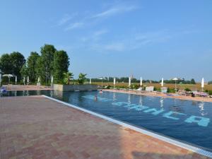 a large swimming pool with people in the water at Characteristic apartment in Codigoro with pool in Codigoro