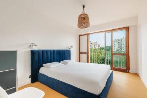 a bedroom with a bed and a large window at Sixties 64 2 bedrooms apartment with a balcony and parking in Biarritz in Biarritz