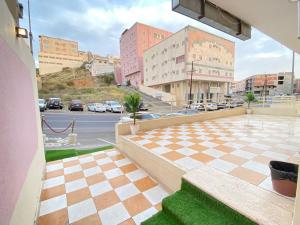 uma varanda com piso em xadrez e uma rua em نماء للشقق الفندقية em Abha