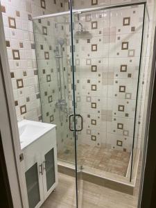 a bathroom with a glass shower with a sink at S.G Apartment Complex. in Linstead