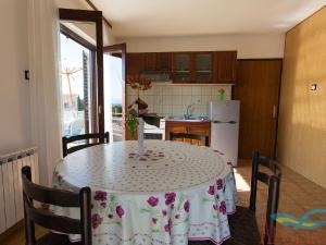 een keuken met een tafel met een tafelkleed erop bij Nice apartment with terrace and grill for use in Malinska