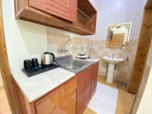 uma pequena cozinha com um lavatório e um WC em نماء للشقق الفندقية em Abha
