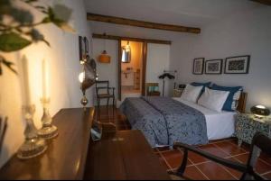 a bedroom with a bed and a table and a table sidx sidx sidx at Beach House Babylon guest house with kitchenette and garden in Torreira