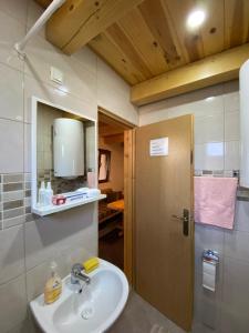 La salle de bains est pourvue d'un lavabo et d'un miroir. dans l'établissement Bungalows and rooms Ivan, à Žabljak