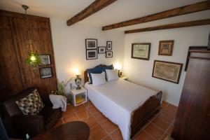 a bedroom with a bed and a chair at Beach House Babylon guest house with kitchenette and garden in Torreira