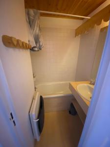 a small bathroom with a tub and a sink at Appartement 4 personnes in Risoul