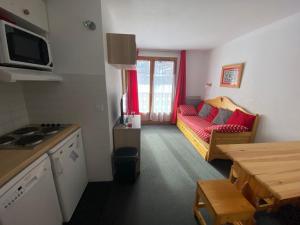 a kitchen and living room with a couch and a table at Appartement 4 personnes in Risoul