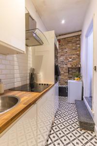 uma cozinha com um lavatório e um balcão em Prime Location - Cosy Apartment near Emirates Stadium em Londres