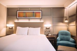 a hotel room with a bed and a chair at Crowne Plaza - Belfast by IHG in Belfast