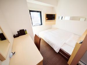 a small room with a bed and a desk at Super Hotel Akihabara Suehirocho in Tokyo