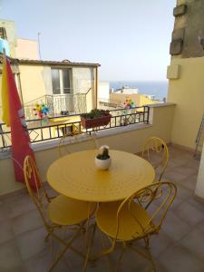 シャッカにあるLa Casuzza di Laraの黄色のテーブルと椅子が備わるバルコニー