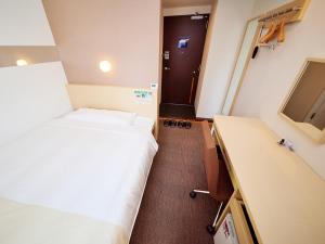 a small room with two beds and a desk at Super Hotel Akihabara Suehirocho in Tokyo