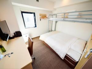 Super Hotel Akihabara Suehirocho في طوكيو: غرفة نوم مع سرير ومكتب وسرير بطابقين