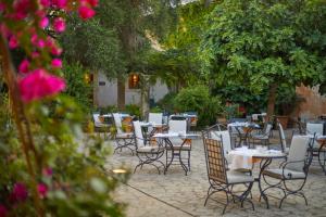 a group of tables and chairs in a garden at Zoetry Mallorca Wellness & Spa in Llucmajor