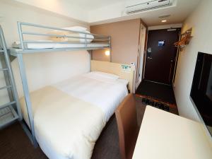 a small room with two bunk beds and a table at Super Hotel Akihabara Suehirocho in Tokyo
