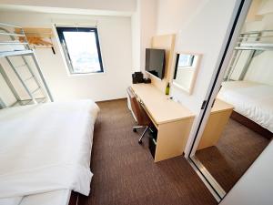 a hotel room with a desk and a bed at Super Hotel Akihabara Suehirocho in Tokyo