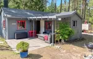 un pequeño cobertizo gris con patio y mesa roja en 4 Bedroom Cozy Home In hus, en Åhus