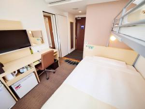 a small room with a bed and a desk at Super Hotel Akihabara Suehirocho in Tokyo