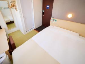 a small room with a large white bed in it at Super Hotel Akihabara Suehirocho in Tokyo