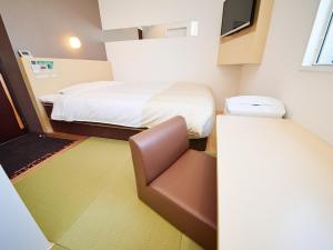 a small room with a bed and a chair at Super Hotel Akihabara Suehirocho in Tokyo