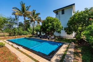 una piscina en el patio de una casa en SaffronStays Lakeview Nivara - Farm Stay Villa with Private Pool near Pune en Pune